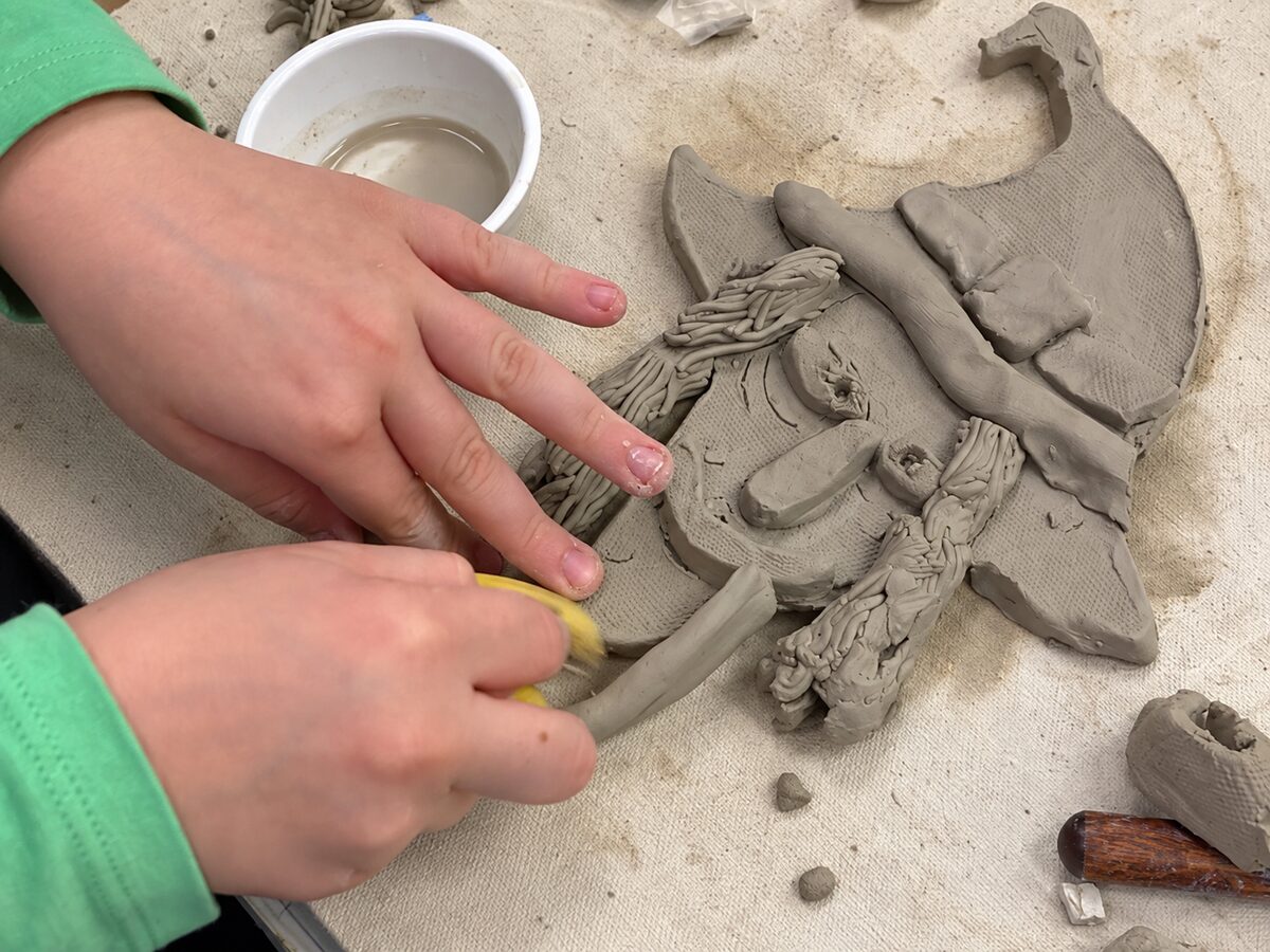 Beginning Art student working on a clay witch face