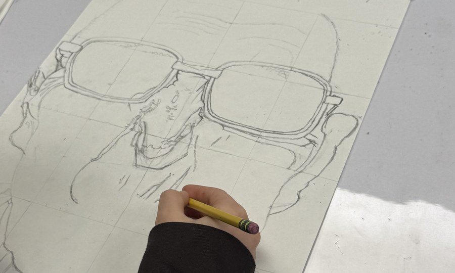 Art 1 student drawing a portrait with a grid